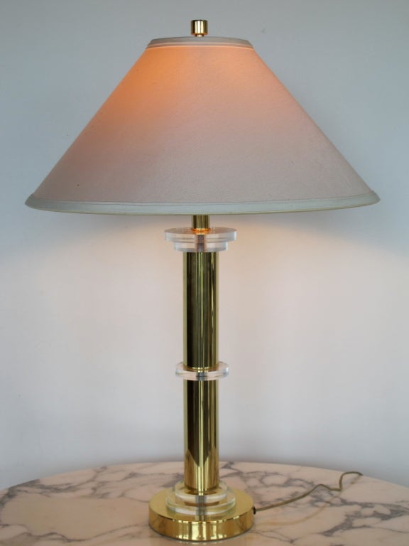 A stylish table lamp by Fredric Cooper, Chicago, IL, in polished brass and lucite with original shade.
