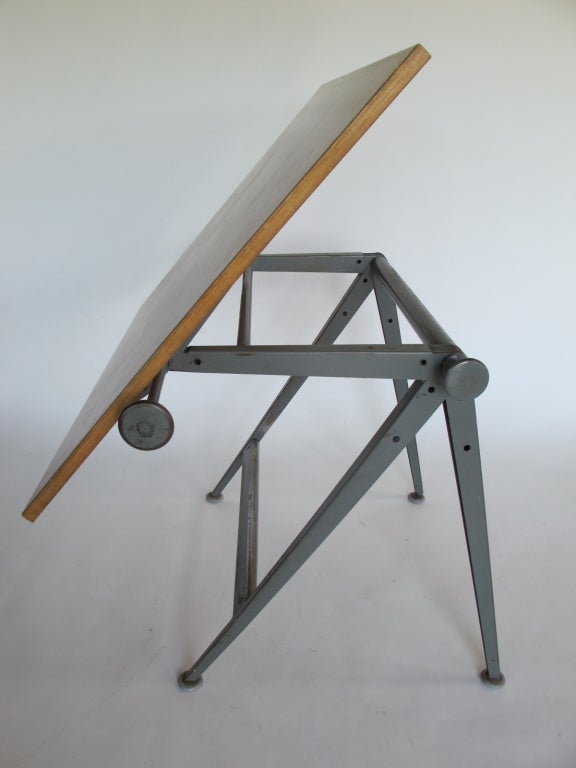 A drafting desk with adjustable top. Great patina, original gray painted metal frame, birch plywood top. A collaboration between Friso Kramer and WIm Rietveld for De Cirkel.