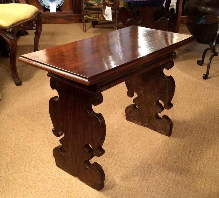 Italian walnut side table with a period Baroque base and a later matched top. Base with handsome carved design, overall rich patina.