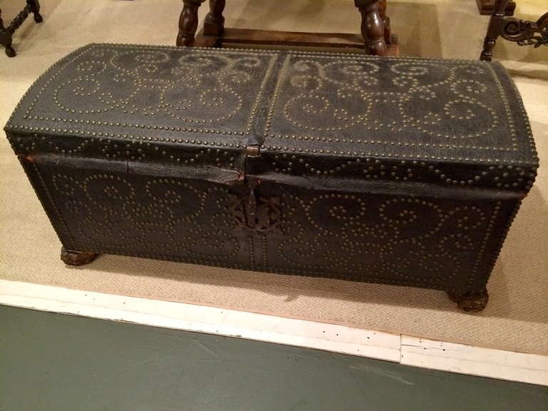 18th century Spanish dome top leather chest with brass nail studding in decorative patterns covering the surface. Original gilt iron handles, lock plate and hasp, also reataining the original 'Spanish' carved wood feet with traces of gilding.