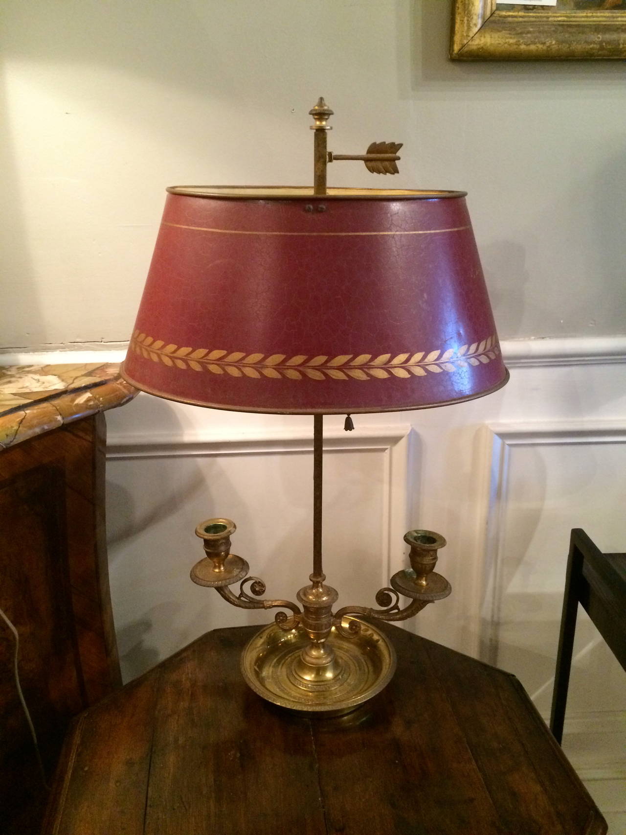 French gilt bronze Charles X bouillotte lamp with original red tole and gilt shade above two candleholders. Now electrified.

Bouillotte is an 18th century French gambling card game of the revolution very popular during the 19th century in France