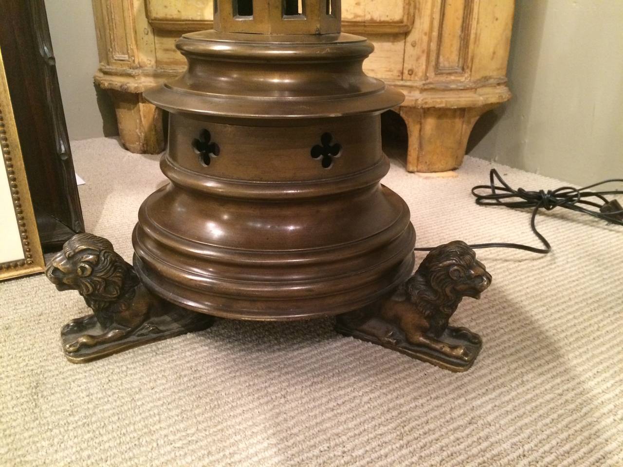 Grand et audacieux candélabre gothique en bronze, aujourd'hui utilisé comme lampadaire, avec une rotation audacieuse reposant sur des pieds tripodes en forme de lion, avec une patine riche et chaleureuse.