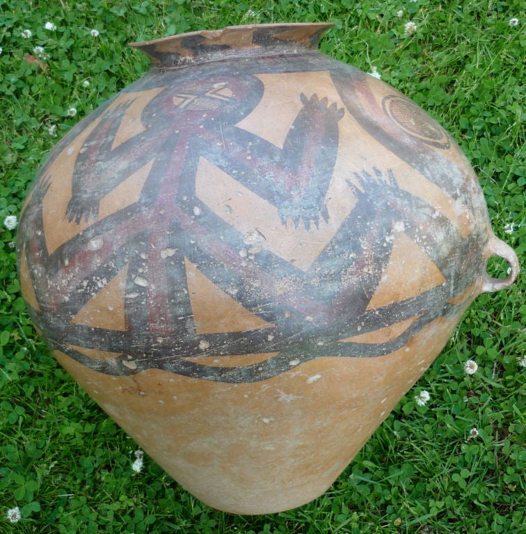 AN UNUSUAL CHINESE PAINTED POTTERY JAR<br />
NEOLITHIC PERIOD, MACHANG PHASE, CA. 2000 B.C.<br />
Of ovoid form, the upper section painted with four rudimentary figures with splayed limbs, in brown edged in cream, all reserved on a pale brown