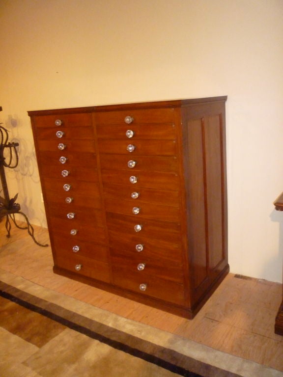 An unusual large scale English mahogany collectors cabinet or apothecary chest with cedar drawers and beautiful hand blown glass knobs. Each of the 22 gradated drawers numbered with a brass tag. <br />
Ex: Milton Academy, Milton Ma.