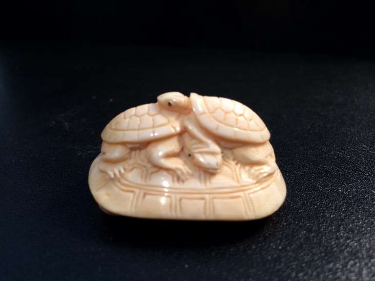 Two ivory turtle netsuke, one with two smaller turtles on top of a larger one, the other depicting a large turtle on a lily pad with a smaller one on it's back. Both showing the whimsy and charm that the best netsuke are noted for. Both with