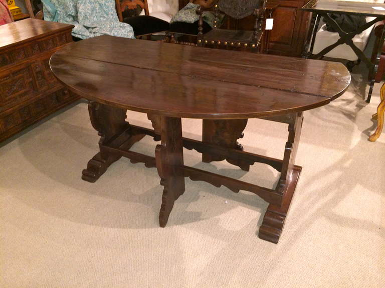 Italian 17th century  walnut drop leaf oval table with beautifully carved supports and stretchers, from Tuscany. Deep, warm patina.