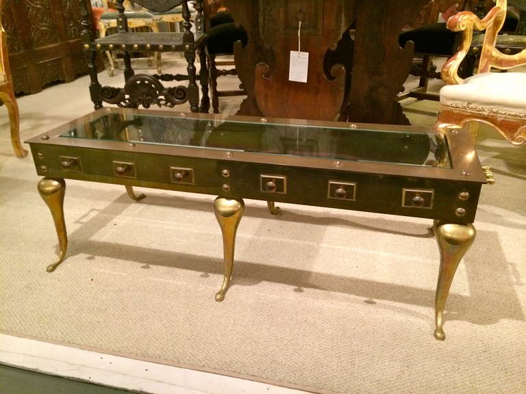 Elegant brass coffee table in the English Georgian style with glass inset top.

Measurements: 
Top- 15h 48w 15.75d 
Legs- 22 deep
