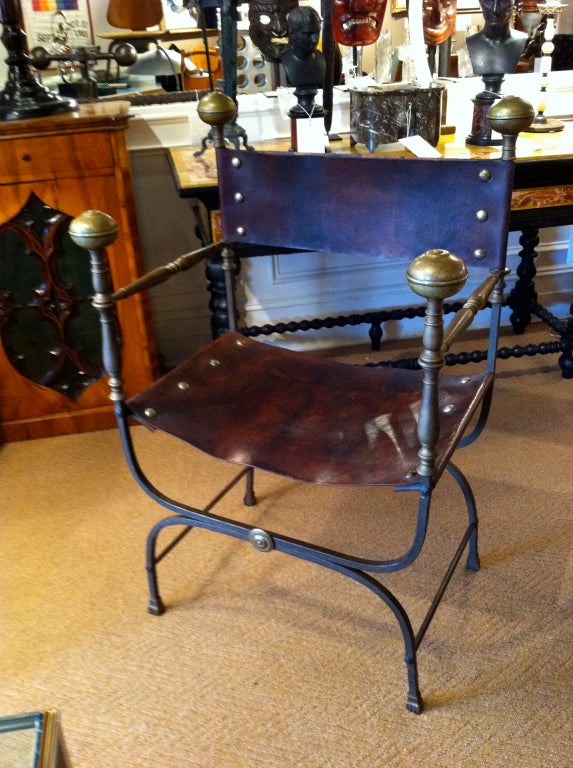 Italian Baroque style wrought iron 'curule' chair with bronze turnings and leather seat.