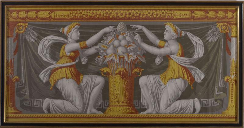 A pair of framed neoclassical French hand printed wallpaper panels depicting two kneeling maidens attending to a cornucopia of fruit and flowers, the curtain behind decorated with a Greek key border. In yellows, reds and grisaille. 
By Zuber & Cie