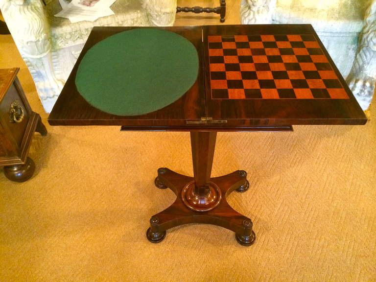 English Regency rosewood gaming table on pedestal base. Closed it makes a handsome side table, opens to a felt surface for cards and a chess board, with storage compartment underneath.

