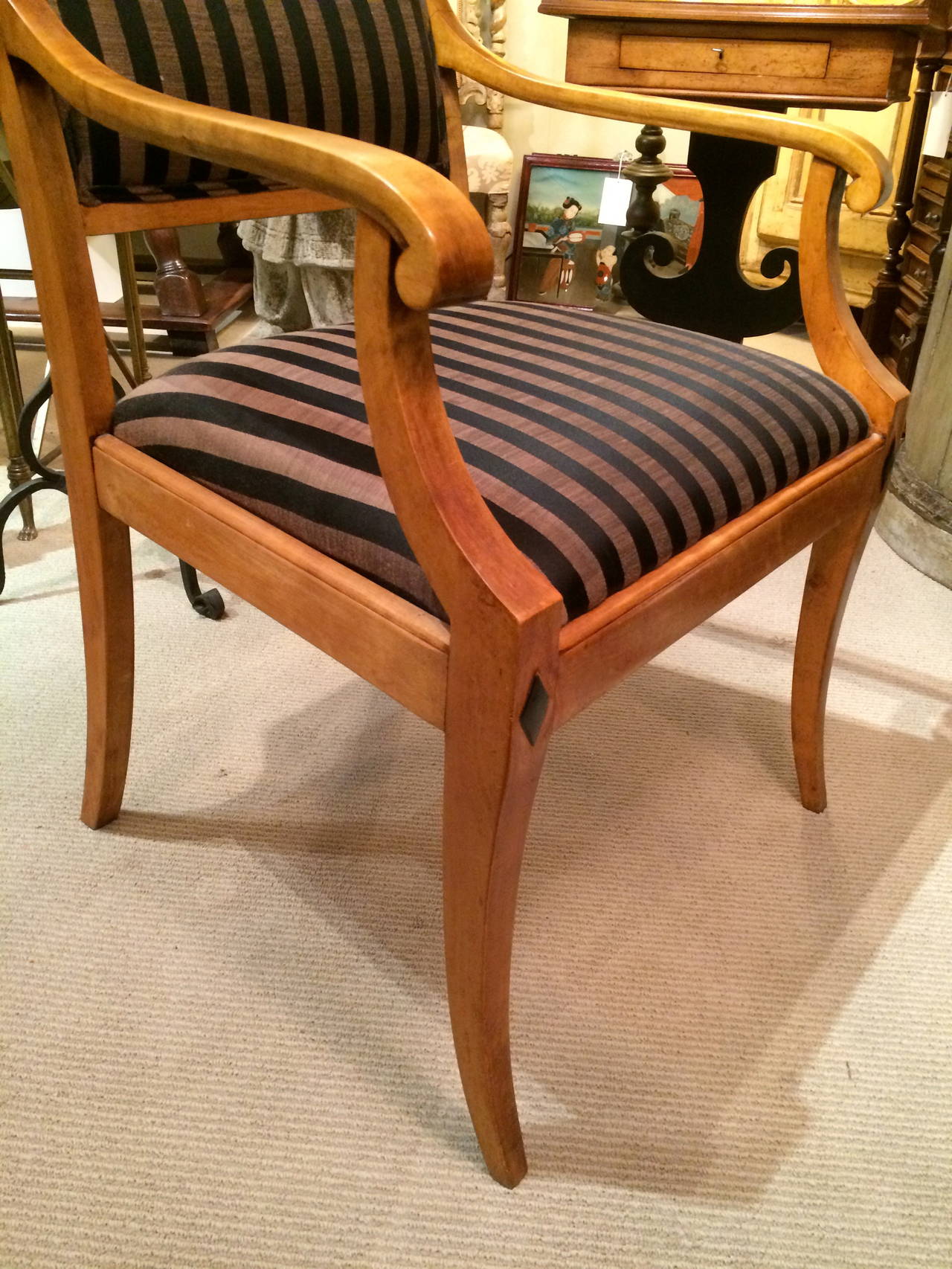 Pair of Austrian Biedermeier neoclassical birch wood upholstered armchairs with ebonized diamond shape inlay.