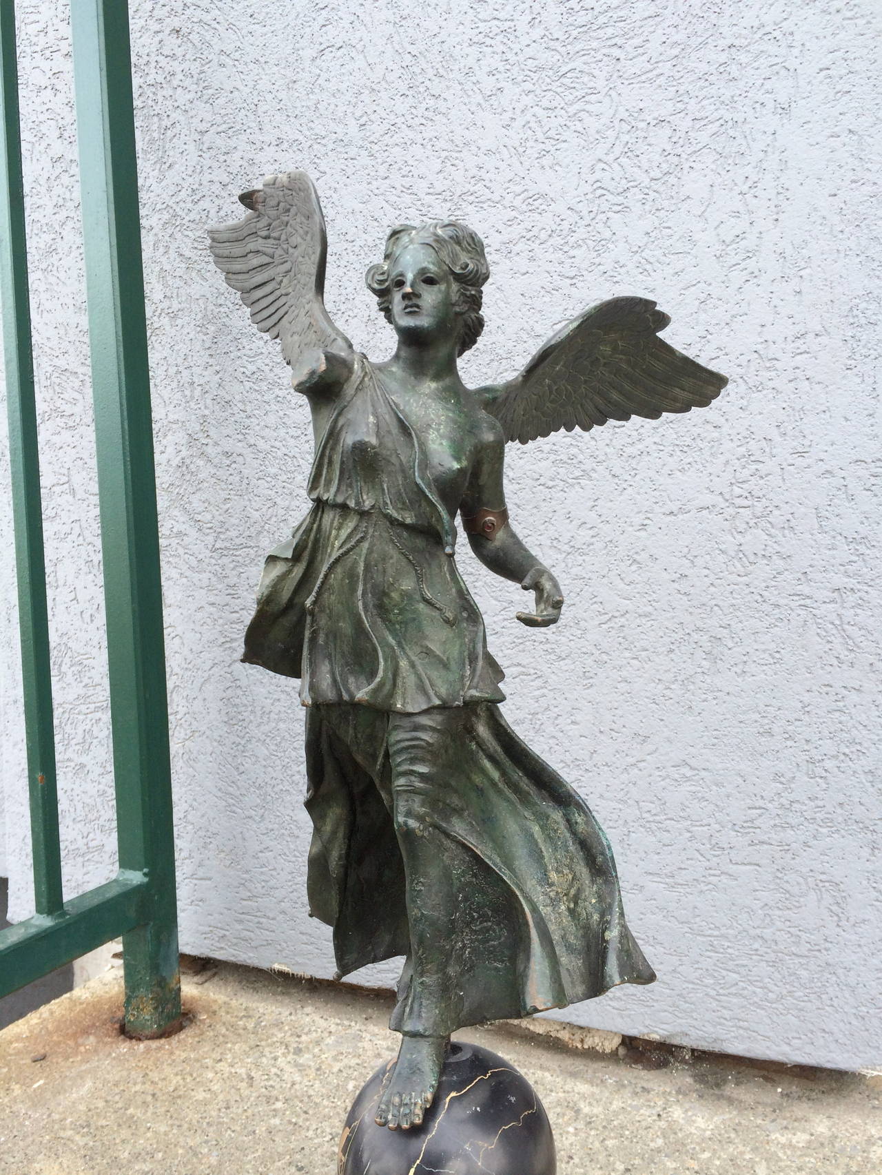 19th century, Italian Grand Tour bronze sculpture of 'Winged Victory' with verdigris patina mounted on a Siena marble base topped by a black marble orb.