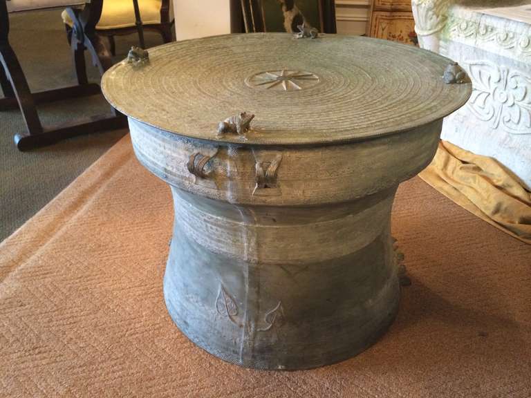 Southeast Asian bronze round 'rain drum' with applied handles, decorated with frogs and elephants as well as geometric and floral designs. Wonderful verdigris patina. These make great side tables.