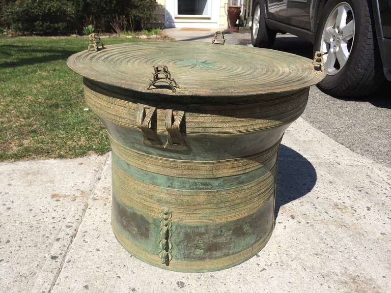 Southeast Asian bronze round 'rain drum' with applied handles, decorated with stylized frogs on the top and elephants on the sides as well as geometric and fish designs. Wonderful verdigris patina. These make great side tables.