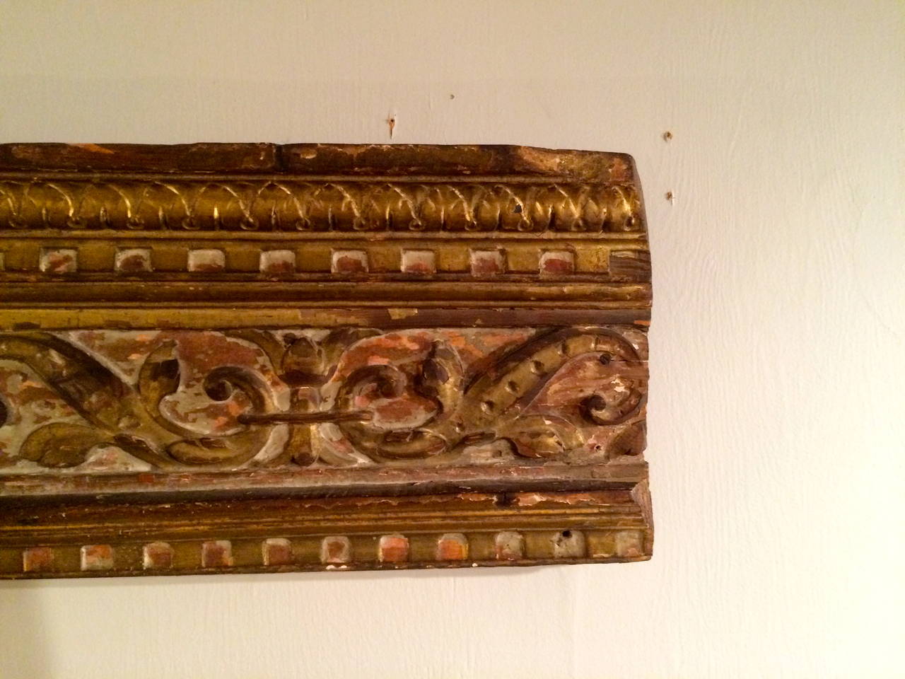 18th century Italian giltwood architectural relief carving with carved floral arabesques, acanthus leaf molding above, dentilated molding above and below. A fine piece of carving with traces of the original reddish paint.

Measures: 37 in / 94 cm