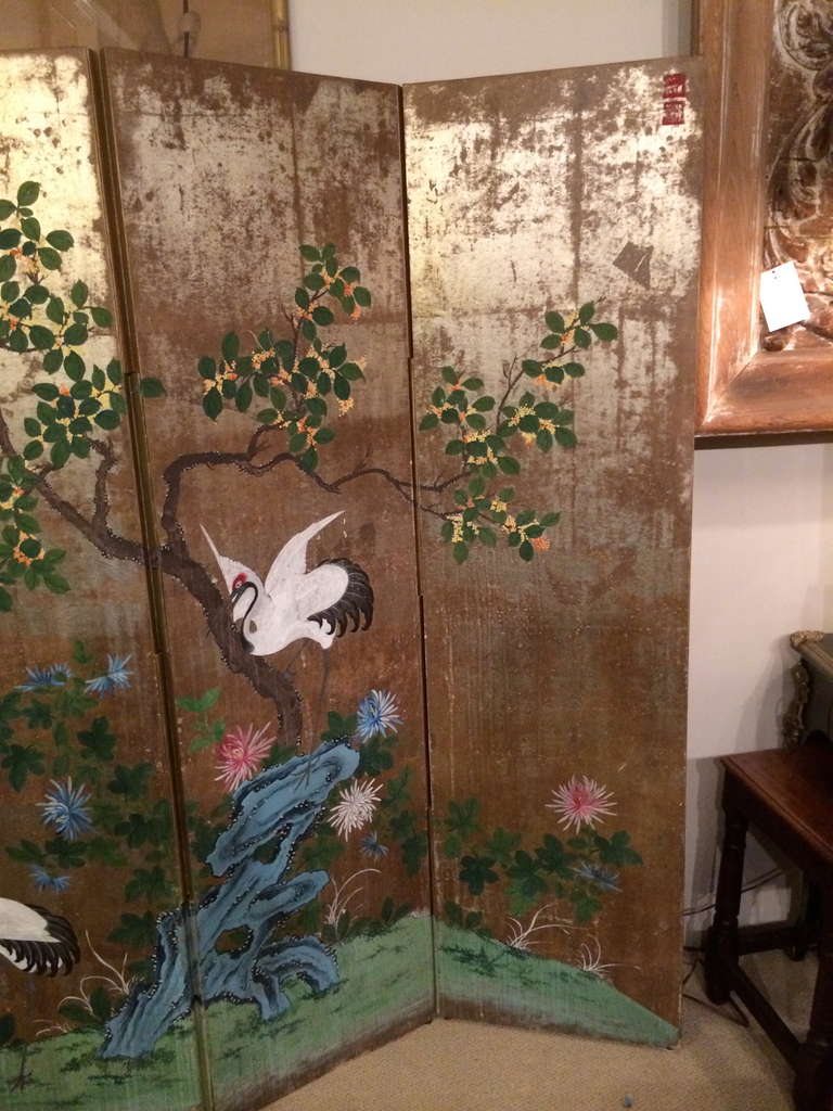 Stunning Japanese style four panel painted screen depicting a tree with cranes and chrysanthemums on a silver leaf ground.