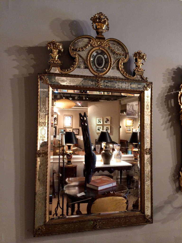 A SWEDISH ORMOLU ETCHED AND ENGRAVED GLASS MIRROR
AFTER THE MODEL BY BURCHARD PRECHT, SECOND HALF 19TH CENTURY
The rectangular plate within a beveled foliate-decorated surround with foliate clasps, the C-scroll arched cresting centered by an oval