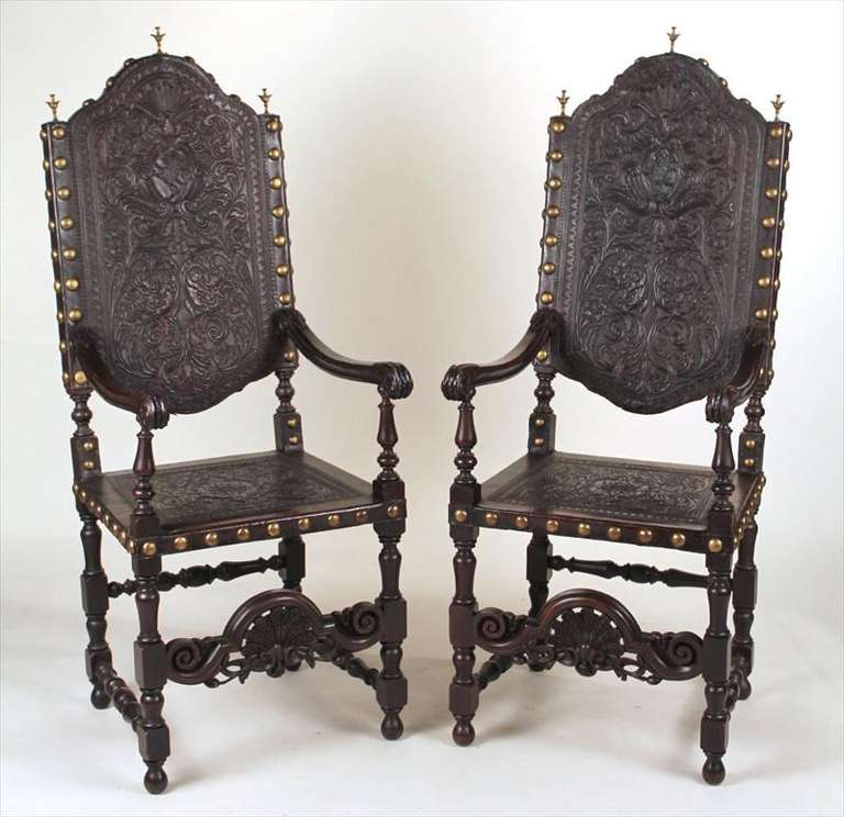 Handsome pair of best quality Spanish or Portuguese Baroque style carved walnut armchairs with tooled leather, bronze nails and finials.