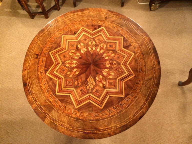 19th century Italian side or center table with elaborate marquetry top inlaid with walnut and various fruit woods, typical of Sorrento, Italy. The tripod base also inlaid with geometric patterns.