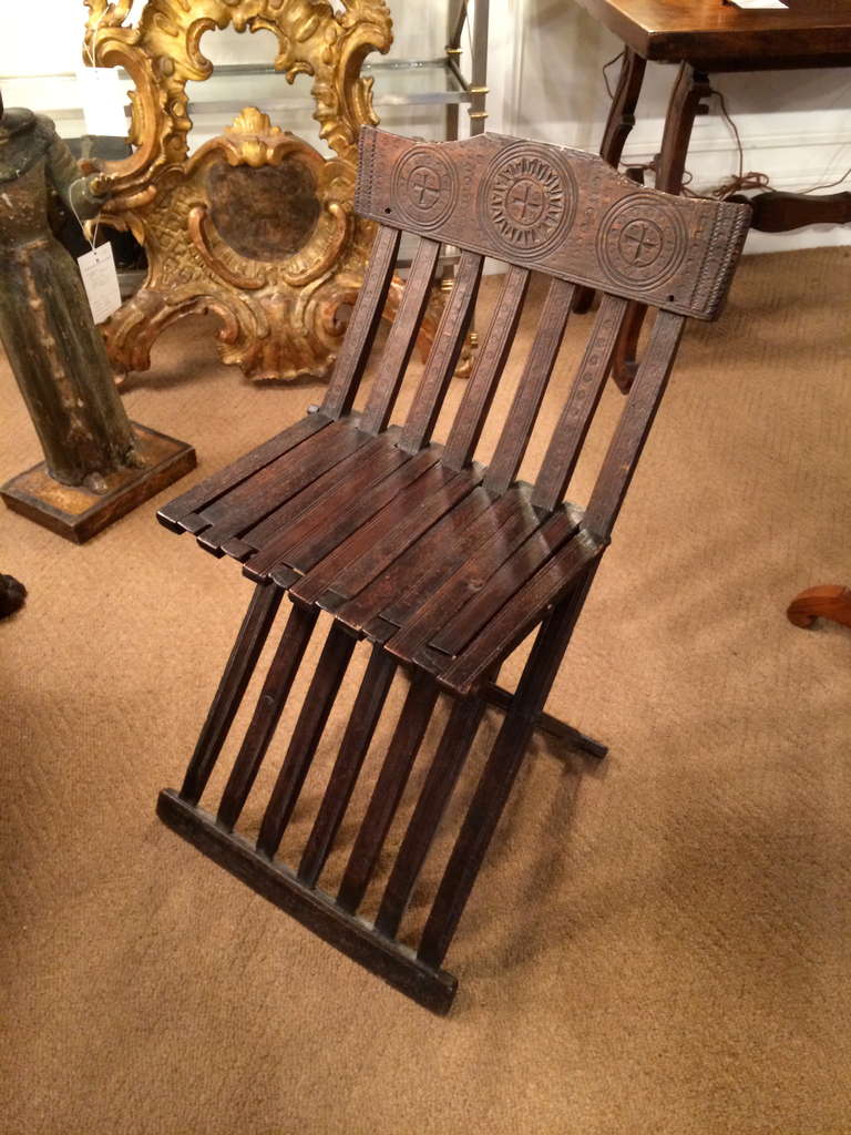 Rare folding chair, known as a 'Pincer' chair, or Sedia Tanaglia. Northern Italian, mid-15th century. Beechwood with incised geometric decoration. This is the smaller side chair version of the Savonarola chair. It's amazing that this chair is still