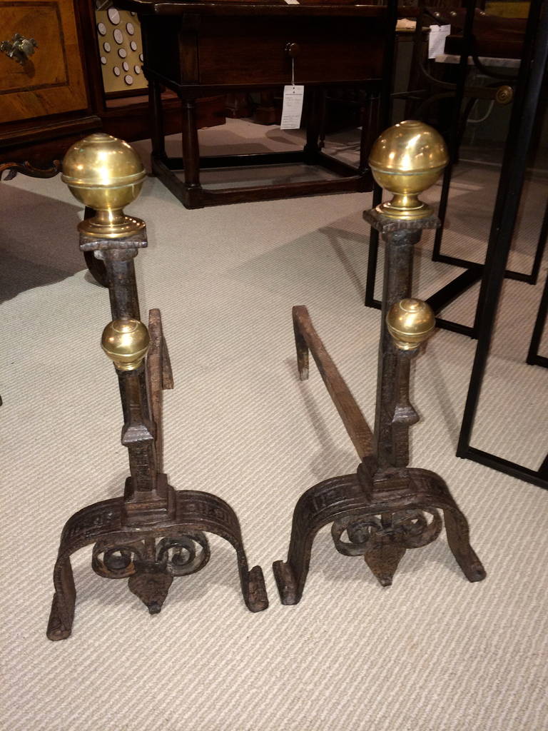 Pair of Italian Baroque wrought iron andirons with etched decoration and brass ball finials.