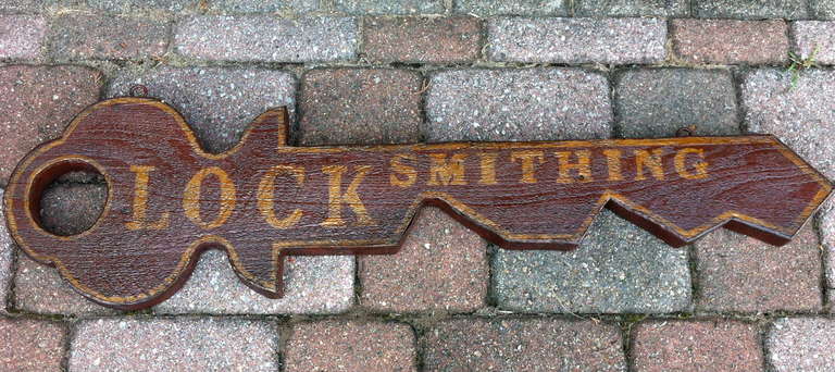 Trade sign depicting a giant key with the word 'Locksmithing' spelled out in whimsical fashion. Original deep red paint with gilt letters and border, applied metal covering the entire outside edges. Great piece of folk art.

Price reduced and FREE