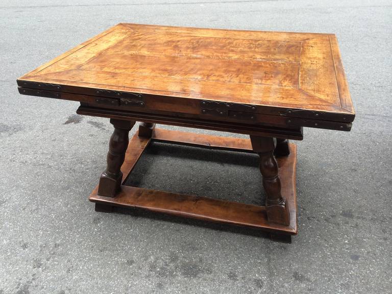 18th century Swiss or German Baroque walnut and wrought iron draw-leaf refectory table. With two hidden leaves that can be drawn out to extend the table. Also makes a very handsome center table. Rich honey patina. 
This versatile table can be used
