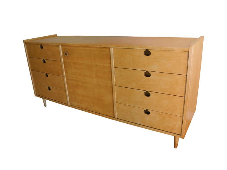 This is a maple storage cabinet used as a dresser, sideboard or office credenza. There are eight drawers. Four on each side with a central cabinet equipped with two shelves (three levels). The sideboard or dresser has been refinished in its natural