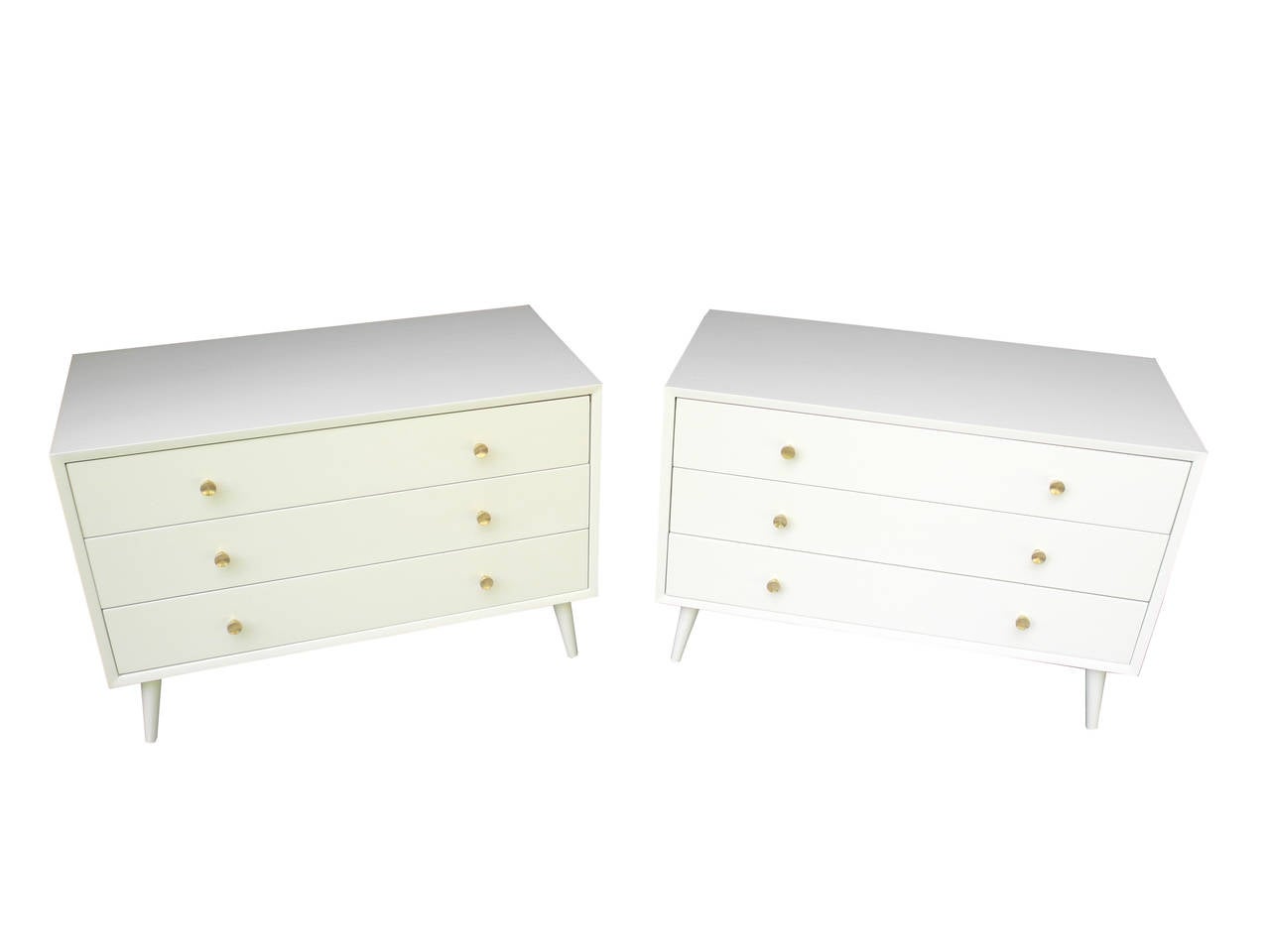 These three-drawer dressers work as bedside tables or placed side by side as a long dresser. Painted and lacquered in an off-white. They have solid brass pulls and are made out of genuine mahogany.