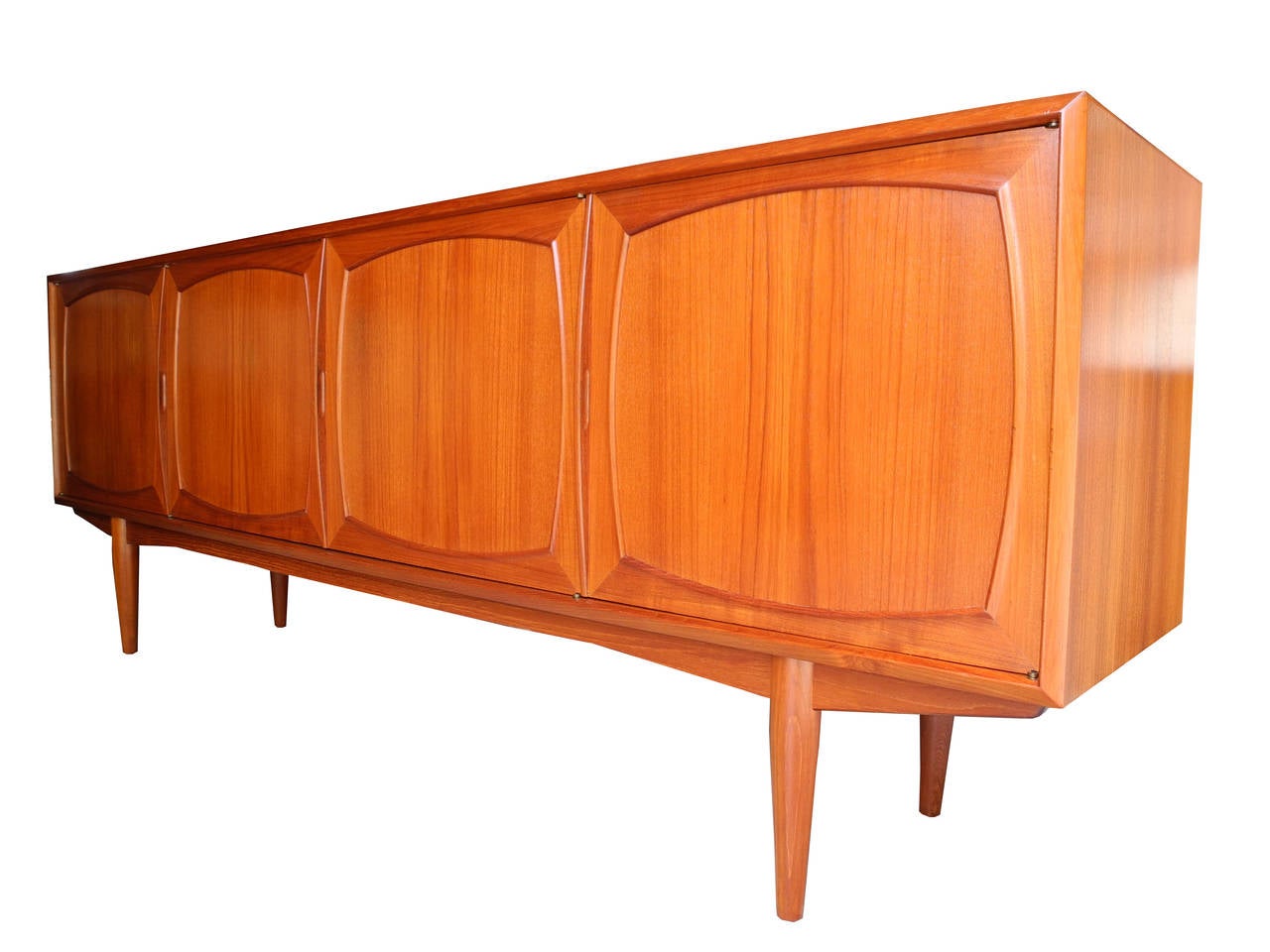 This beautifully designed teak sideboard offers a large amount of storage. Two side cabinets, one with glass shelves, one with drawers. And a middle cabinet with a single long shelf. Recently refinished. Ready to go condition.
