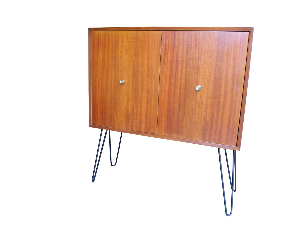 Award winning architect, Morris Sanders designed this cabinet made of mahogany with solid brass pulls. It sits on hairpin metal legs and is 
equipped with one adjustable shelf inside a shallow cabinet.