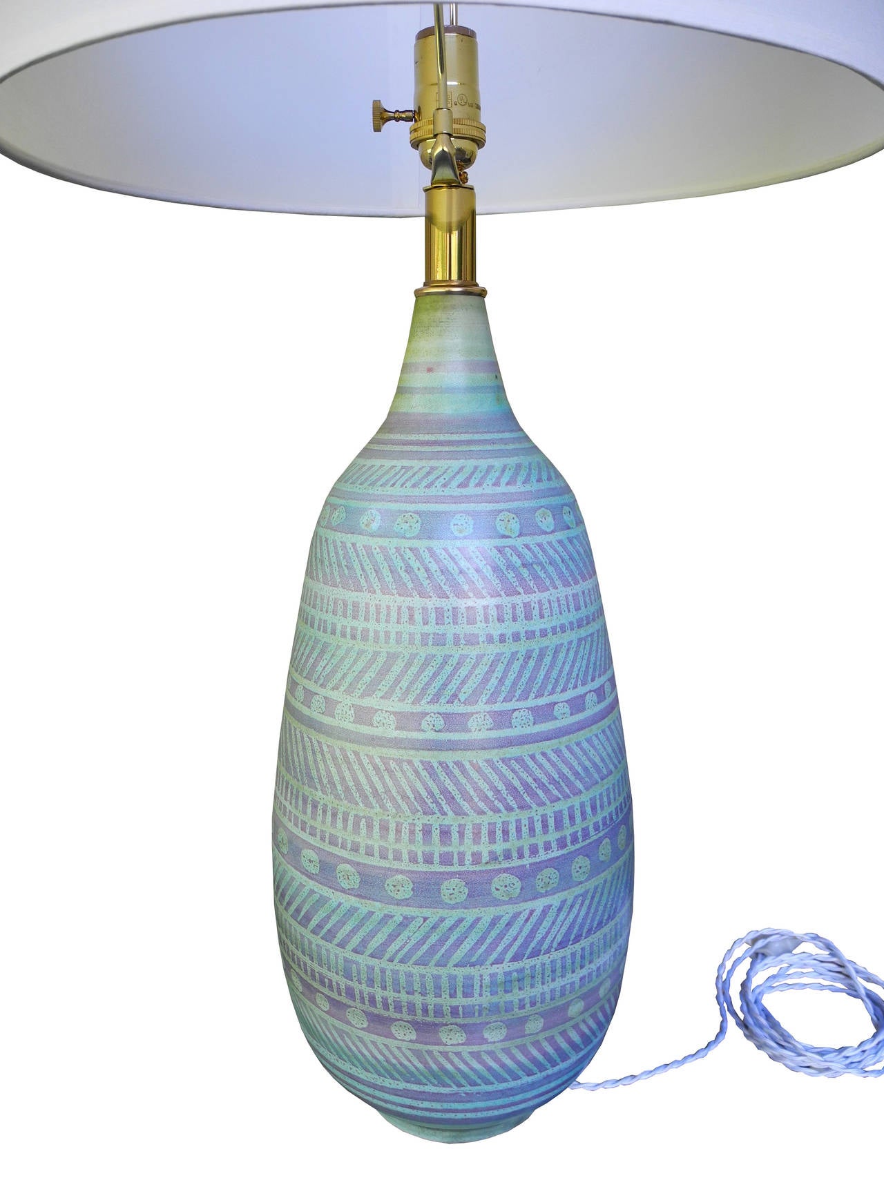 Beautiful handmade ceramic lamp by Design Technics in a lavender, turquoise and green glaze. Rewired with a white silk twisted wire and brass socket.
Top if the finial measures 28 inches. Top of the ceramic measures 19 inches.
The diameter of the