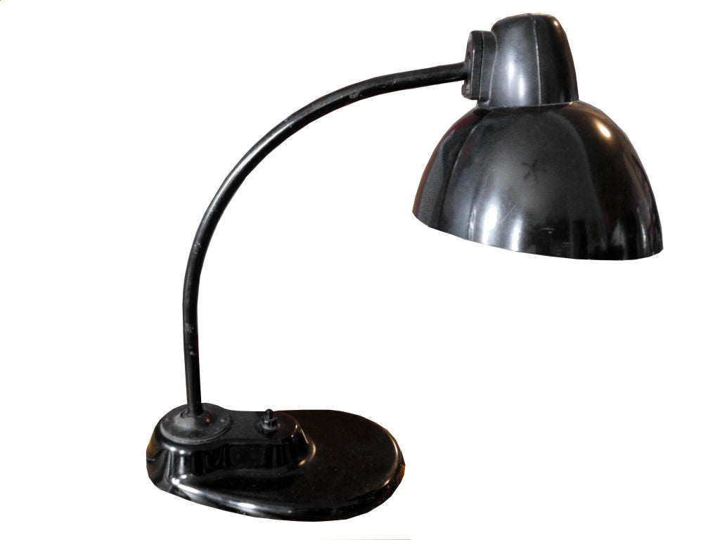 Seminal German Kandem Bauhaus Industrial desk lamp by Marianne Brandt. It has a bakelite shade, glass base and metal arm in fine vintage condition. For a desk, table or nightstand; shine a light in the bedroom, living room or office.

 