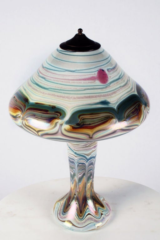 A craftsman table lamp with a colorful pulled feather design over opal-white ground glass shade and body, signed to the underside of the shade 