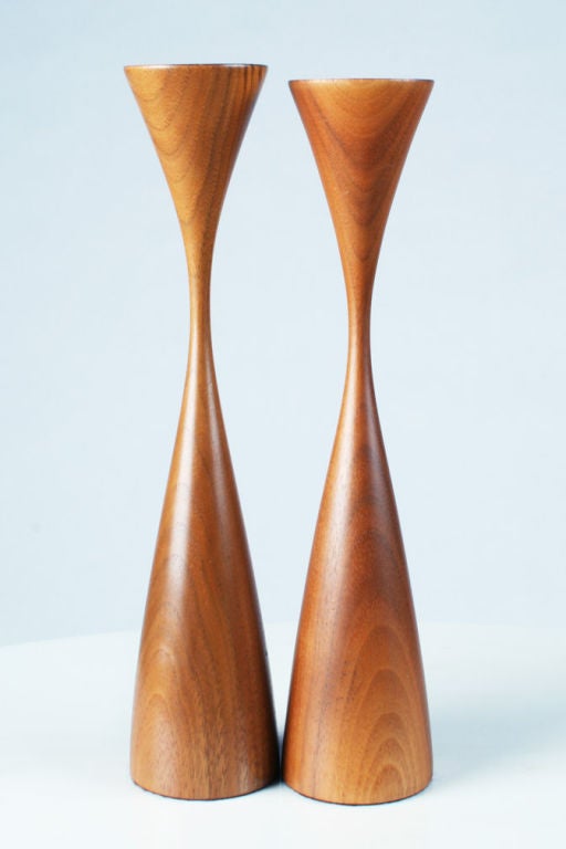 A pair of scultural candlesticks made from turned walnut; each in an elongated hourglass form, one slightly shorter than the other.  Rude Osolnik's pieces are part of permanent collections at distinguished museums such as the Boston Museum of Fine