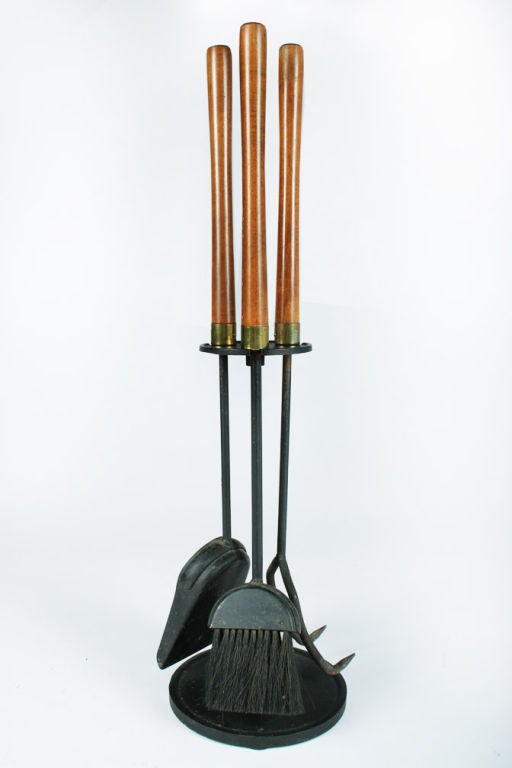 A set of three firetools with long walnut handles supported by an integral wrought iron stand in a circular form. By Seymor Manufacturing Company. U.S.A., circa 1950.