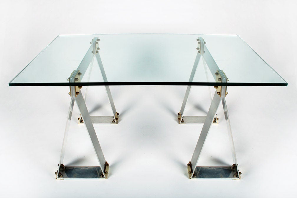 A industrial chic work table or desk with saw horse bases in polished aluminum with polished brass fittings.  Glass not original to the piece. French, circa 1970.