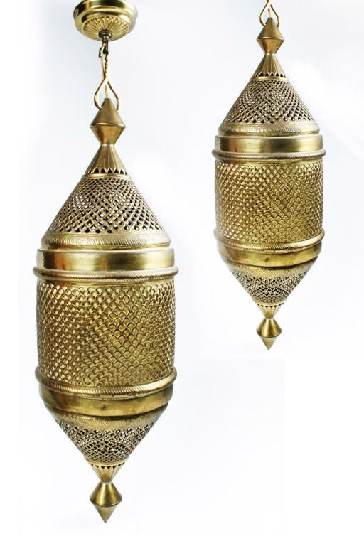 An exotic pair of very large pendants in lantern form made in pierced brass with muslin around the inside for diffusing the light.  By Sarna Lantern.  Circa 1960.