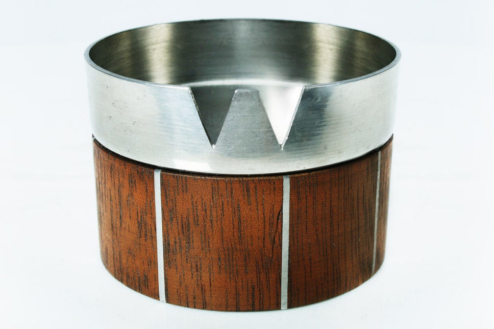 A smart ashtray in walnut with inlaid pewter detail and a brushed metal top. Probably a collaborative design by Paul Evans and Phillip Lloyd Powell. With metal tag to bottom [Designers Inc. Paul Evans]. U.S.A., circa 1960.