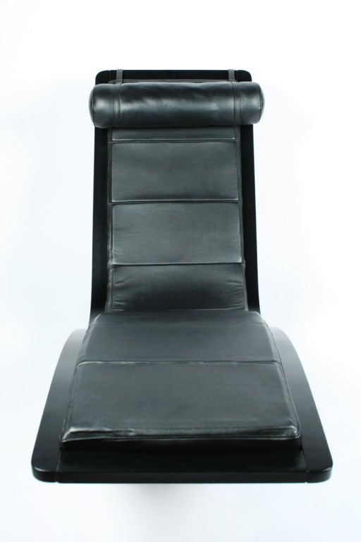 A sculptural rocking chaise lounge in black painted laminated wood frame with leather upholstery and adjustable, counterbalanced headrest.   Designed by Oscar Niemeyer manufactured by Fasem. Italian, circa 1970.