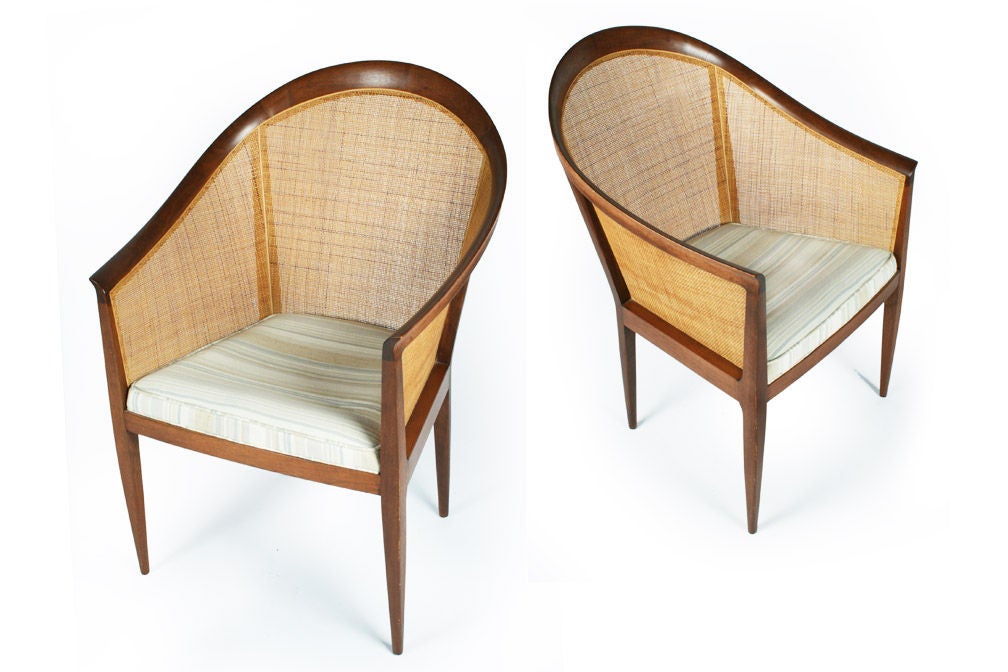 A graceful pair of armchairs with walnut frames in a curved and caned back and upholstered seat.  By Kipp Stewart for Directional. American, circa 1960.

Please call gallery for details, availability and item location.