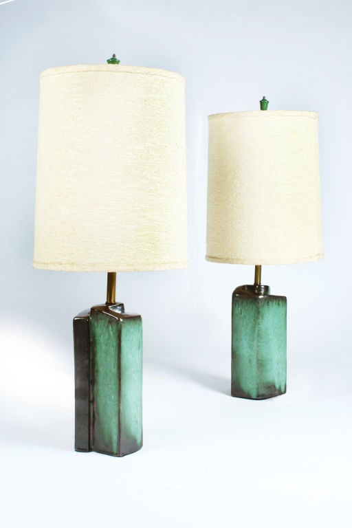 A pair of ceramic table lamps in a Cubist spiral form of thick folded slabs encircling a brass rod, finished in a vibrant green and deep green glaze with original finials and shades.  By Marianna Von Allesch for Carola Ceramics.  American, circa