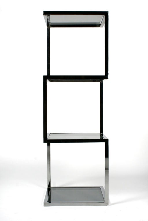 A chic étagère comprising an asymmetrical polished chrome frame of three stacked cubes with four smoked glass inset shelves. After Milo Baughman. U.S.A., circa 1960. [DUF0385]