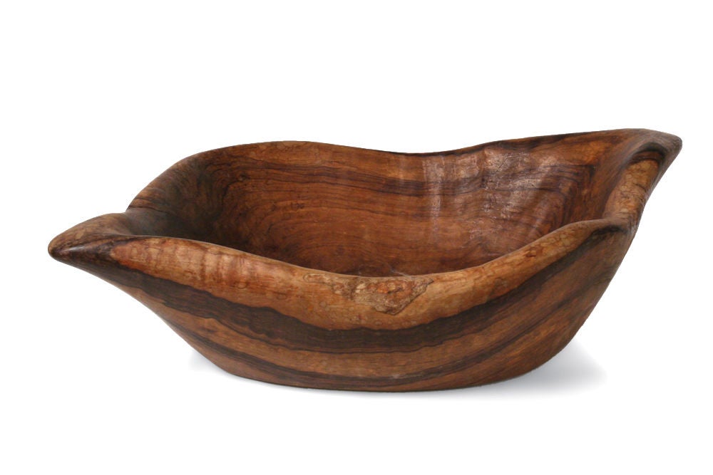 An organically shaped wooden bowl hand carved from a single piece of wood.  Signed with a carved 