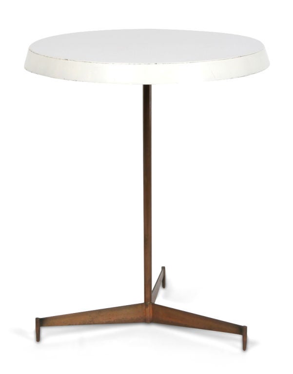 A cigarette occasional table with a circular top with a wide beveled edge raised on a thin brass tripod base. Denmark, circa 1960.