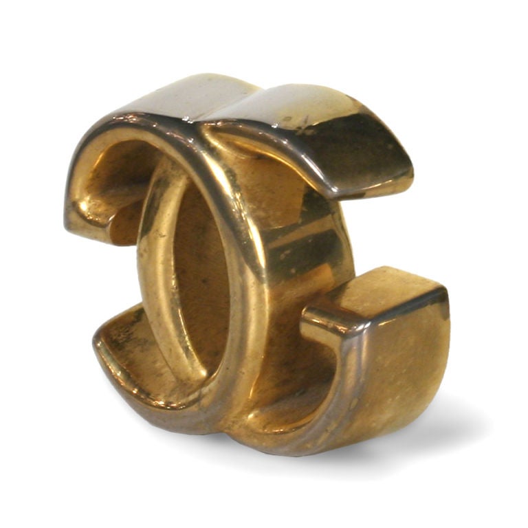 A chic desk accessory paperweight with interlocking 'G' in brass.  Weighs close to one pound. Marked to underside. By Gucci. Italy, 1970.