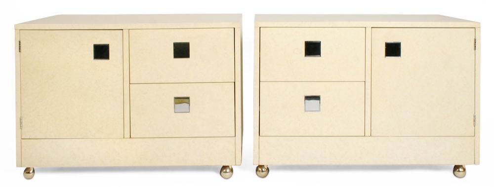 A pair of white lacquered wood nightstands in a simple rectangular form, each comprised of a door concealing a compartment with a single shelf along with two drawers, all with flush face touch-pivot square chromed metal pulls, the whole resting on