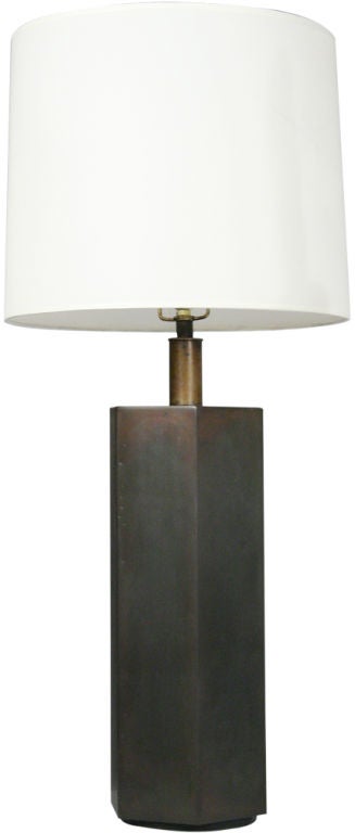 A geometric table lamp in a hexagon column-form in antique bronze patina finish raised on a circular base. By Chapman. U.S.A., circa 1960.