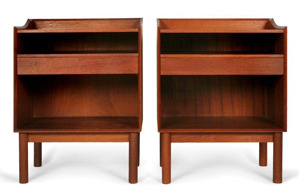 A classic pair of Danish Modern nightstands or telephone tables. Solid teak construction with a partial gallery edge to top and expressed square finger joint joinery to lower corners of cabinet structure. Configured with a shallow shelf and drawer,