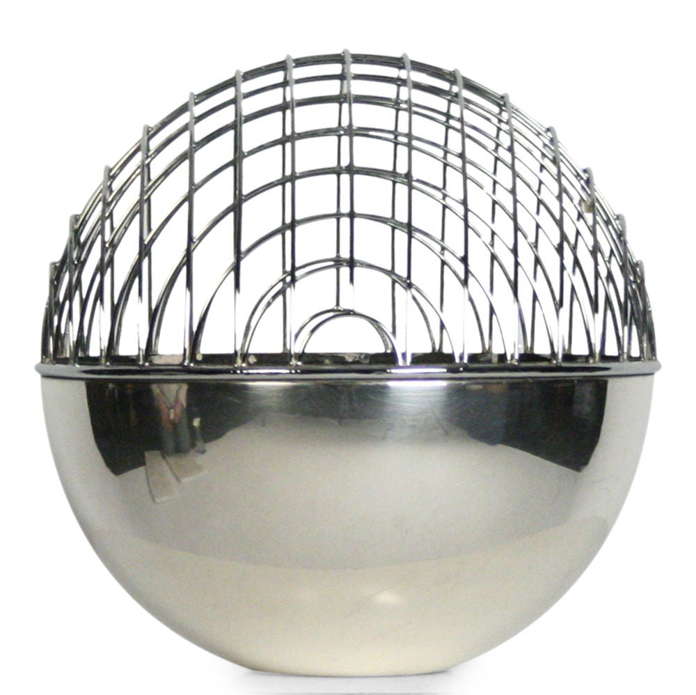 A Magellano silverplate flower frog in an orb shape with wire mesh top hemisphere and solid lower hemisphere filled with glass marbles. The largest of three sizes of the design. Stamped to the base 